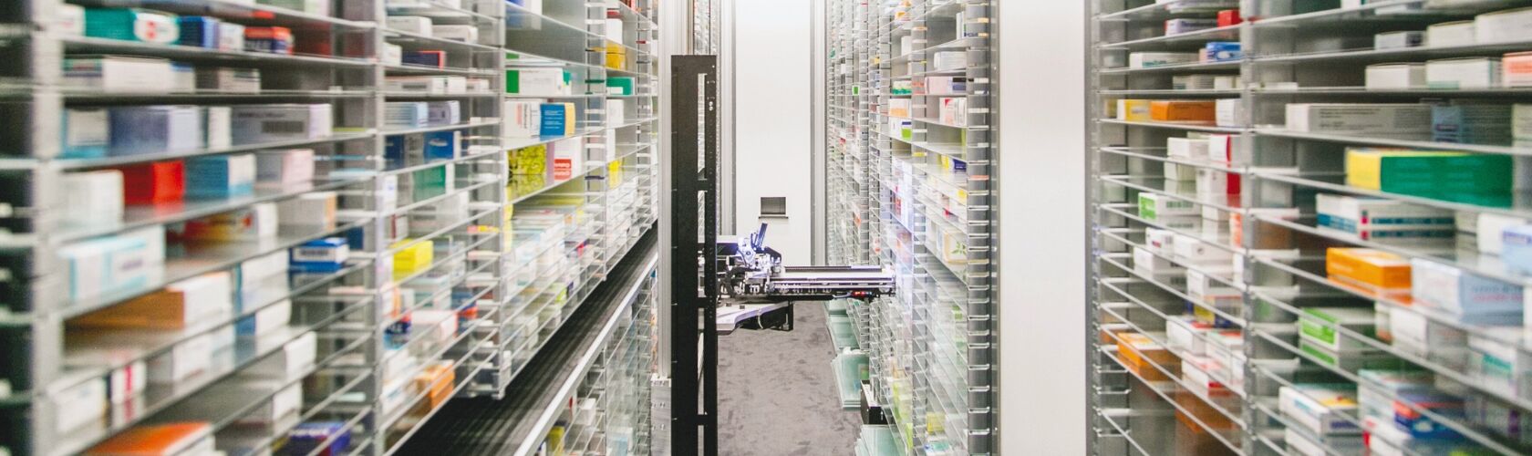 Ein automatisiertes System in einer Apotheke sortiert Medikamente in hohen Regalen effizient für die Reservierung.