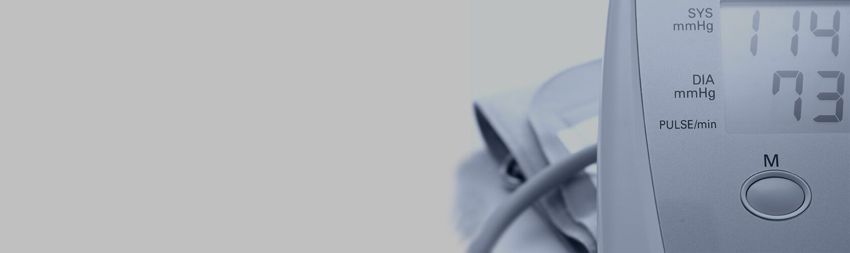 Ein digitales Blutdruckmessgerät zeigt die Messwerte 114 zu 73 in einem medizinischen Serviceumfeld an.